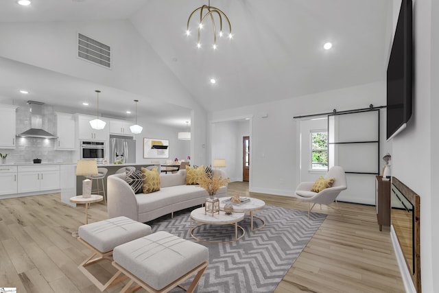 living room featuring light hardwood / wood-style floors, high vaulted ceiling, and an inviting chandelier