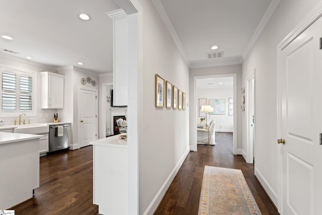 hallway featuring dark hardwood / wood-style floors, ornamental molding, and sink