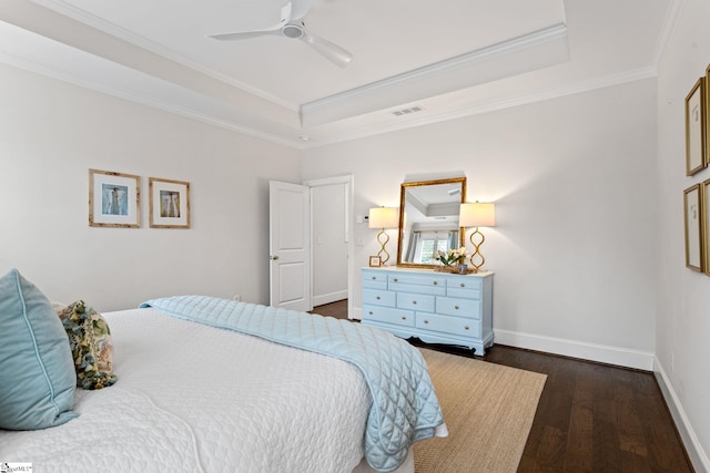 bedroom with ceiling fan, crown molding, dark wood-type flooring, and a tray ceiling