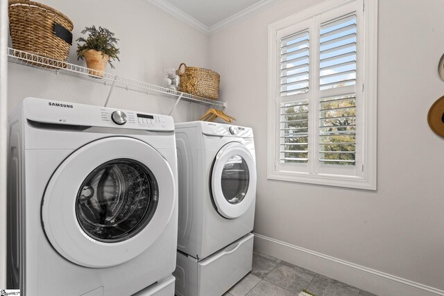 laundry area featuring washer and clothes dryer, a healthy amount of sunlight, and crown molding