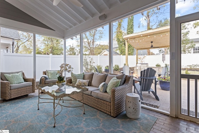 sunroom / solarium with ceiling fan and lofted ceiling