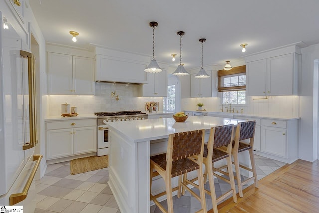 kitchen with white cabinets, a kitchen island, a kitchen bar, and white appliances