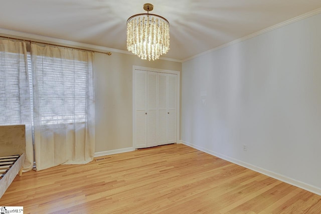 unfurnished dining area with a chandelier, wood-type flooring, and crown molding