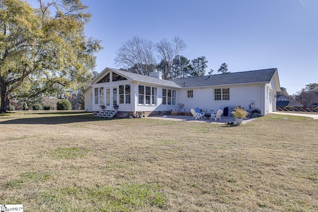 back of house featuring a patio, a lawn, and a sunroom