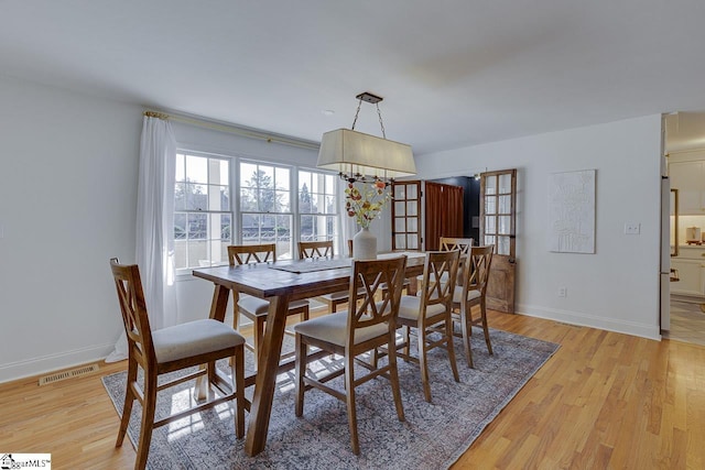 dining space featuring french doors and light hardwood / wood-style flooring