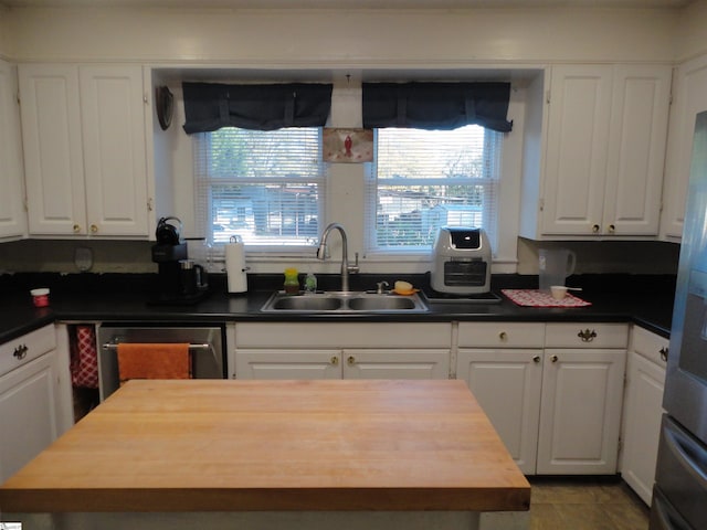 kitchen with dishwasher, white cabinetry, sink, and fridge