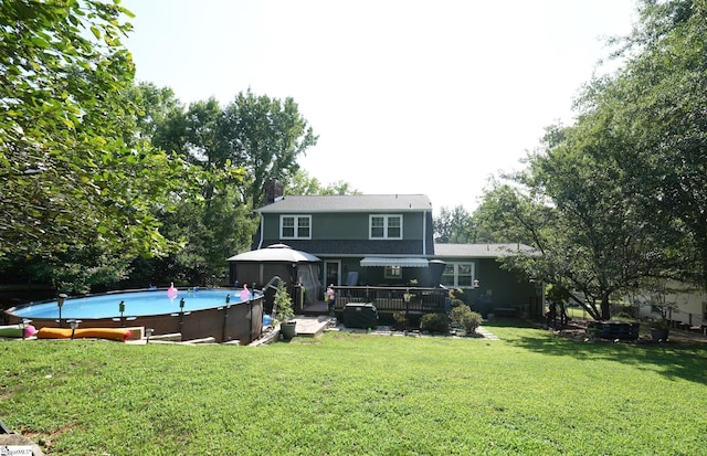 rear view of house with a gazebo, a pool side deck, and a yard