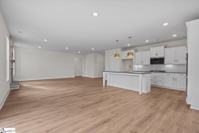 kitchen featuring sink, tasteful backsplash, light hardwood / wood-style flooring, pendant lighting, and white cabinets