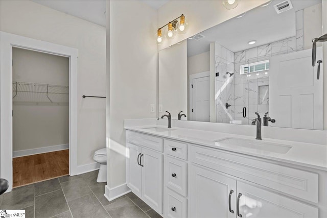 bathroom with tile patterned flooring, vanity, toilet, and a shower with shower door