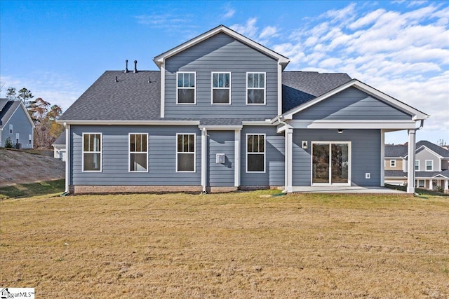 back of property with a patio area and a yard