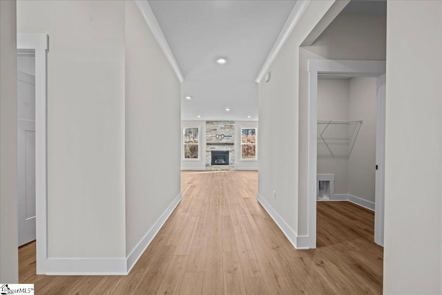 hallway with light hardwood / wood-style floors and crown molding