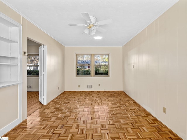 spare room with ceiling fan, a wealth of natural light, and light parquet floors