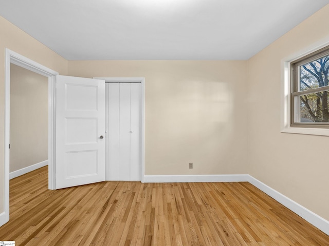 unfurnished bedroom featuring light wood-type flooring and a closet