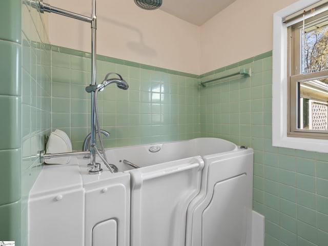 bathroom featuring a bathtub and tile walls