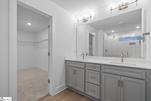 bathroom featuring hardwood / wood-style floors, vanity, and a shower with door