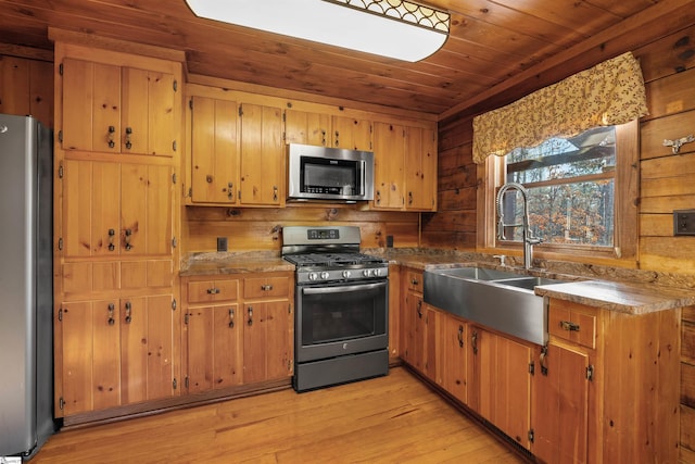 kitchen featuring sink, wooden ceiling, stainless steel appliances, wooden walls, and light wood-type flooring