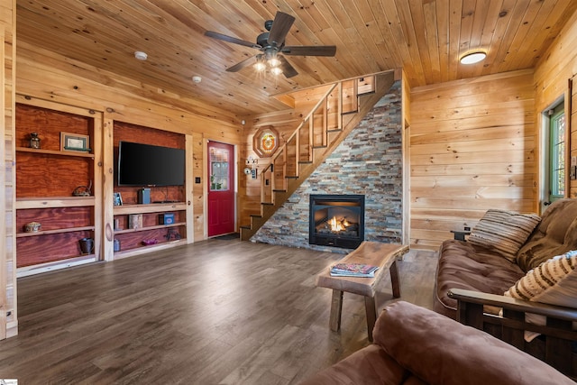 living room with a stone fireplace, wooden walls, dark hardwood / wood-style floors, ceiling fan, and wood ceiling