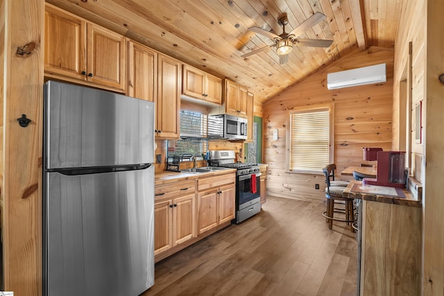 kitchen with a wall mounted AC, wood walls, stainless steel appliances, and lofted ceiling