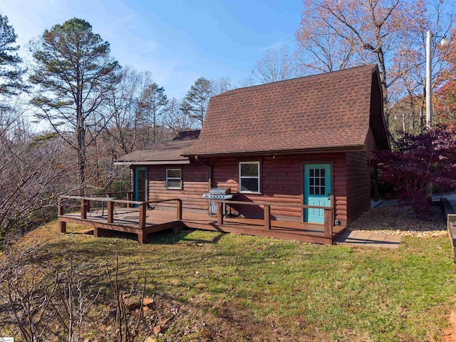 rear view of house featuring a lawn and a wooden deck