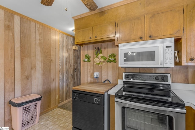 kitchen featuring dishwasher, stainless steel electric range oven, and wood walls