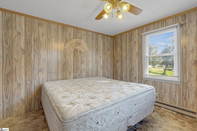 bedroom with carpet flooring, ceiling fan, wood walls, and a baseboard heating unit