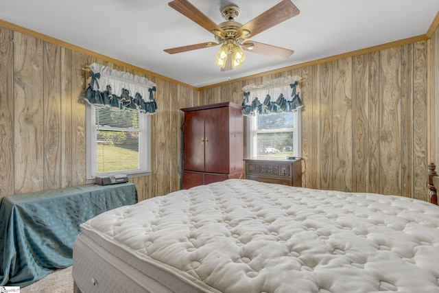 bedroom featuring crown molding, multiple windows, wooden walls, and ceiling fan