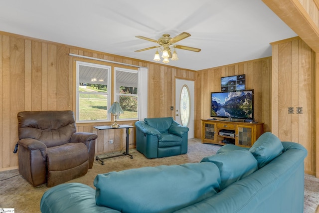 living room with light colored carpet, ceiling fan, and wood walls