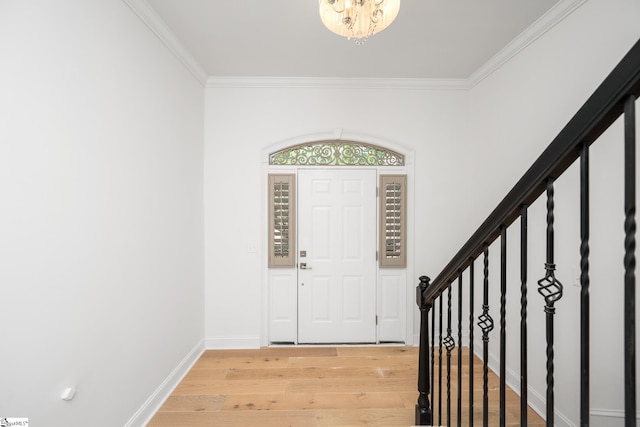 foyer entrance featuring crown molding, hardwood / wood-style floors, and a chandelier