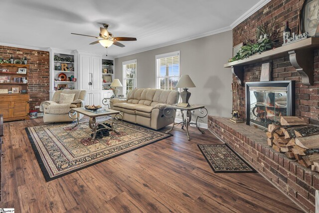 living room featuring a brick fireplace, ceiling fan, crown molding, dark wood-type flooring, and built in features