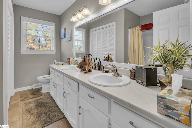 bathroom featuring tile patterned flooring, vanity, and toilet