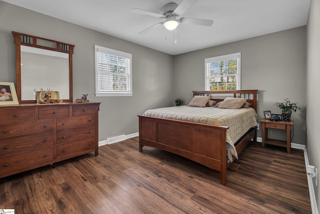 bedroom with multiple windows, ceiling fan, and dark wood-type flooring