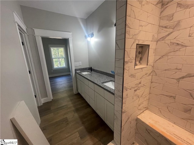 bathroom featuring hardwood / wood-style floors, vanity, and tiled shower