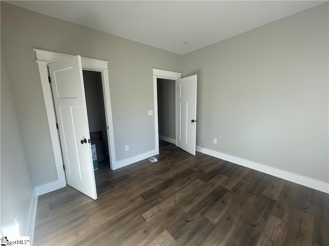 unfurnished bedroom with dark wood-type flooring