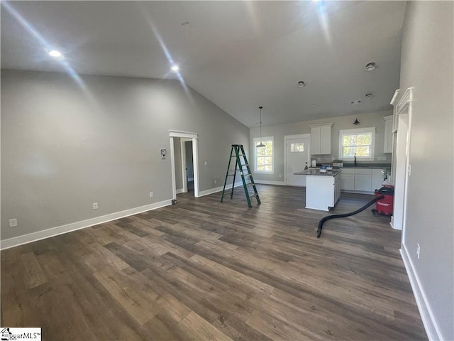 interior space featuring dark hardwood / wood-style floors, sink, and vaulted ceiling