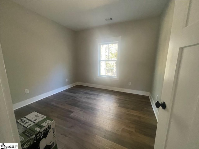 spare room featuring dark hardwood / wood-style flooring