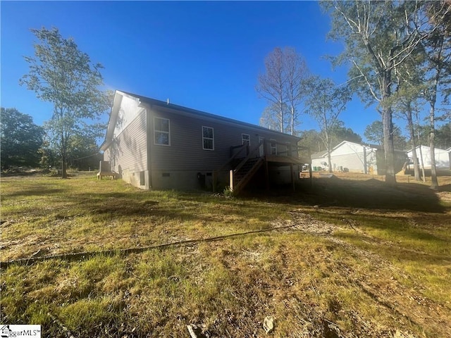 back of house with a deck and a lawn