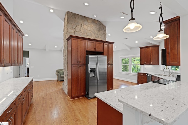 kitchen with light stone countertops, hanging light fixtures, light hardwood / wood-style floors, lofted ceiling, and appliances with stainless steel finishes