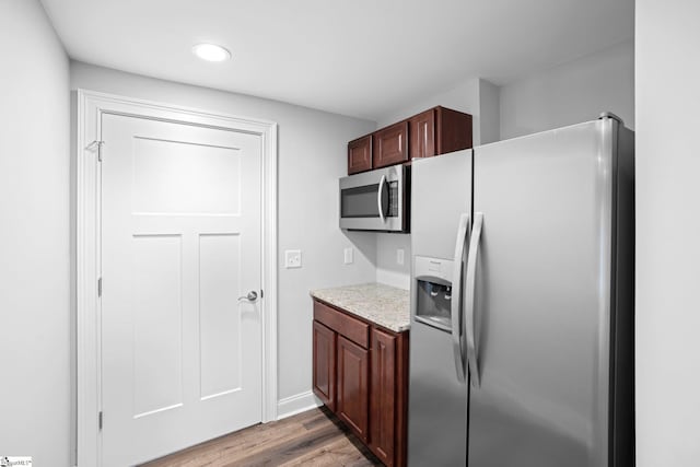 kitchen with stainless steel appliances and hardwood / wood-style flooring