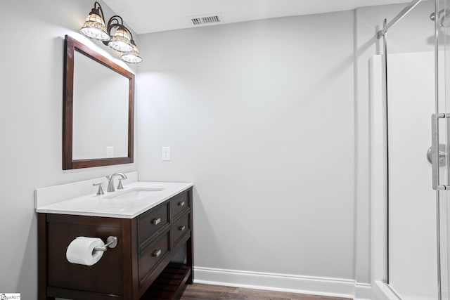 bathroom featuring a shower, hardwood / wood-style floors, and vanity