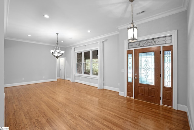 foyer entrance with hardwood / wood-style flooring, an inviting chandelier, and ornamental molding