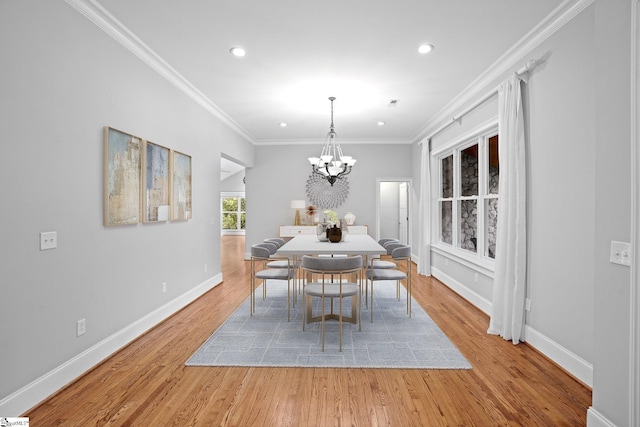 dining room featuring a chandelier, light wood-type flooring, and crown molding