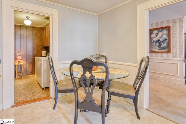 dining area with washer and clothes dryer, crown molding, and light carpet