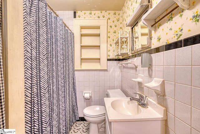 bathroom with tile patterned flooring, vanity, toilet, and tile walls