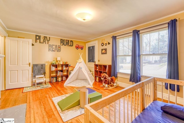 rec room featuring wood-type flooring and crown molding