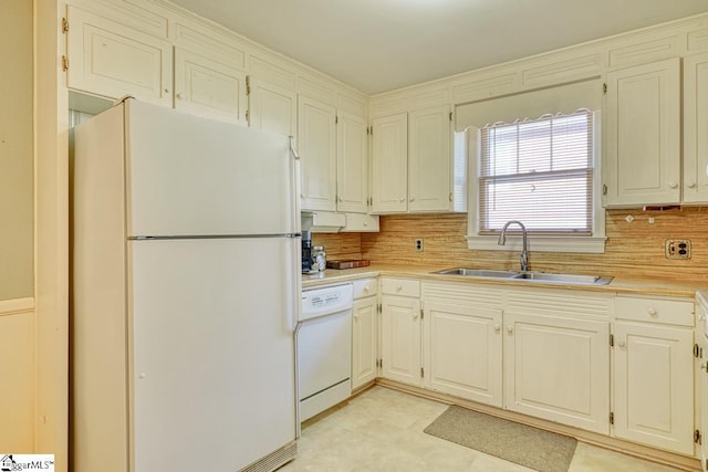 kitchen with decorative backsplash, white appliances, and sink