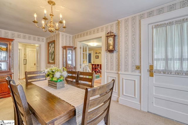 carpeted dining area featuring a chandelier