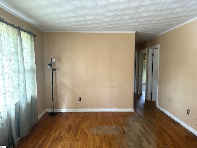 empty room featuring baseboards, wood finished floors, and ornamental molding