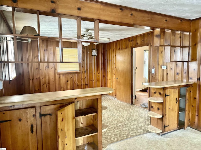 kitchen featuring a ceiling fan, wooden walls, and open shelves