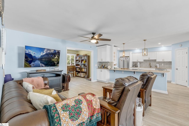 living room with ceiling fan and light hardwood / wood-style flooring