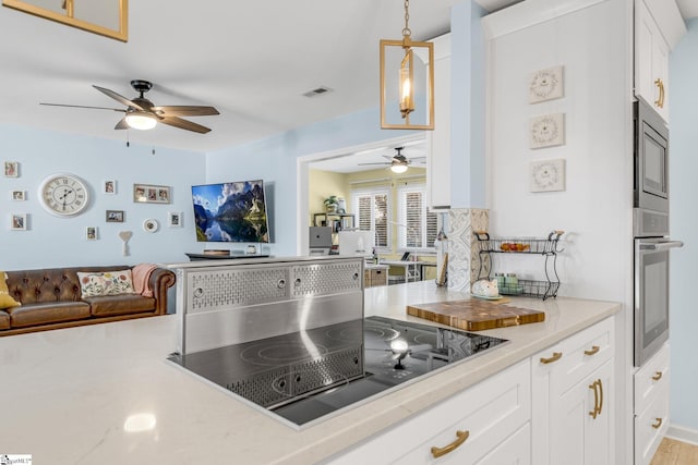 kitchen with white cabinetry, light hardwood / wood-style flooring, kitchen peninsula, pendant lighting, and appliances with stainless steel finishes